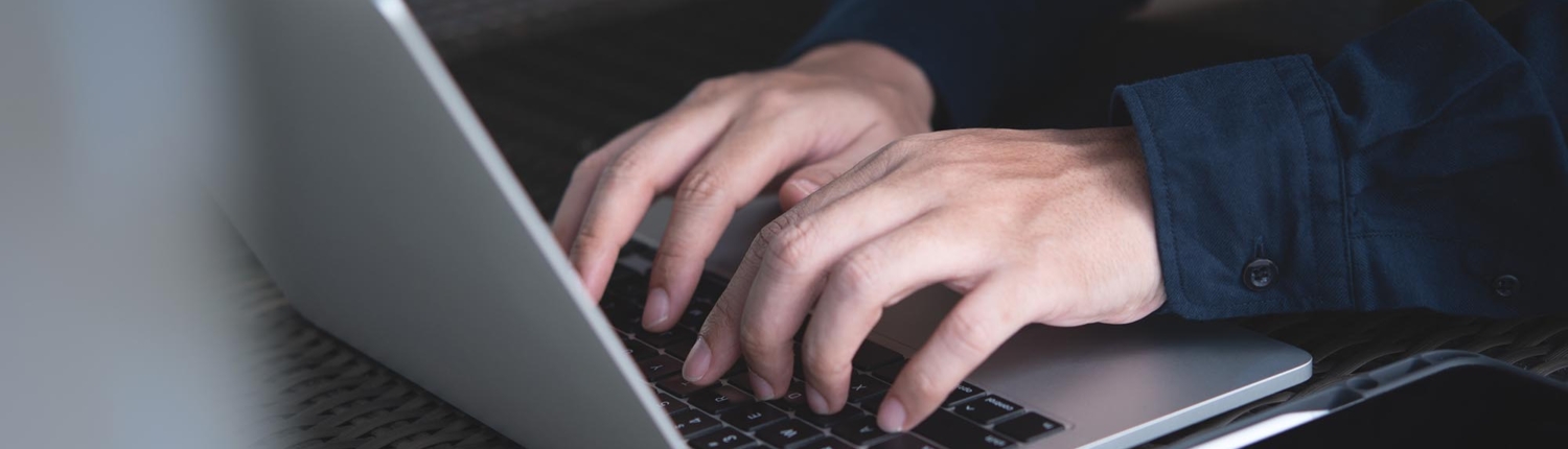 Close up of a pair of hands working on a computer